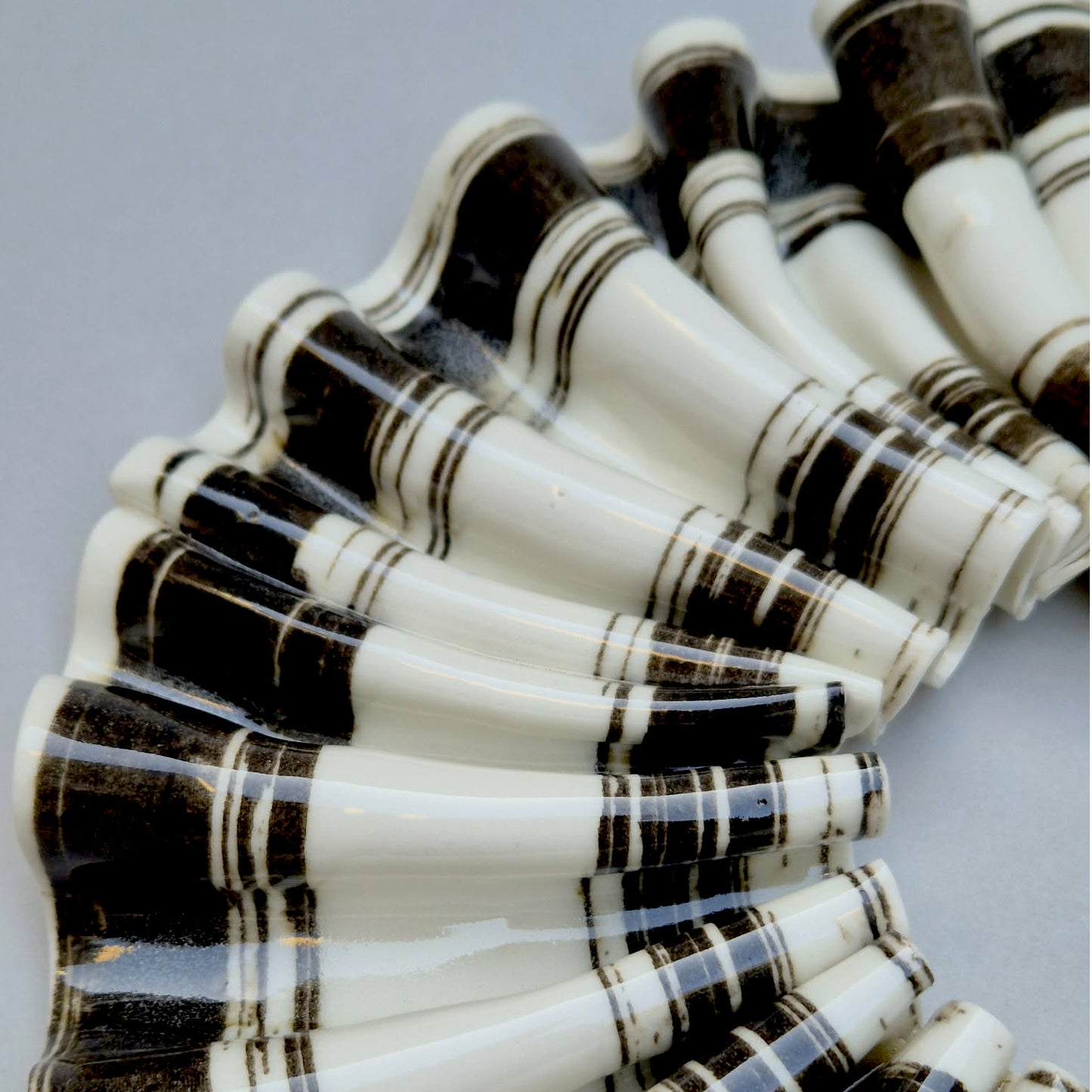 Sort/hvid stribet bølget rosette med guld